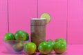 Tahiti lemon juice and fruits Citrus Ãâ latifolia in wooden cup on pink background